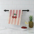 Striped towel with cherry design hanging on a kitchen wall