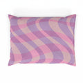 Decorative pillow with pink and purple wavy pattern on a white background